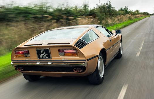 Maserati Bora vue arrière roulant sur route de campagne