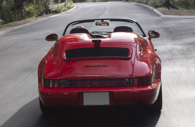 Porsche 911 964 Speedster rouge roulante vue arrière sur route