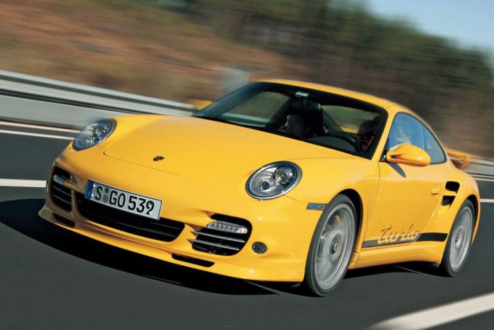 Porsche 911 Turbo type 997 jaune en action sur route avec aileron arrière fixe