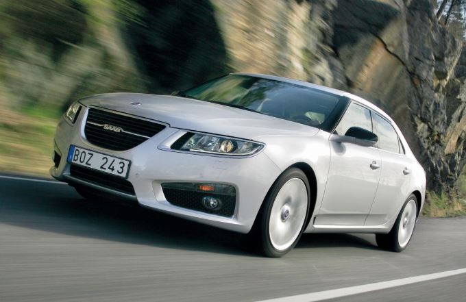 Saab 9-5 blanche en mouvement sur route de montagne