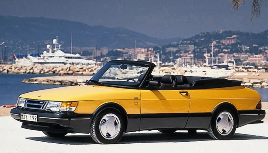Saab 900 cabriolet jaune décapotable au bord de mer