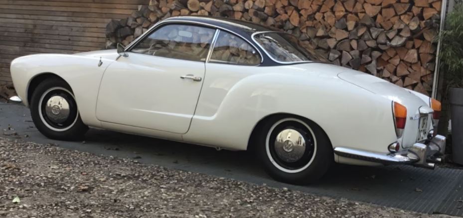 Volkswagen Karmann Ghia 1969 blanc garé devant un mur de bois