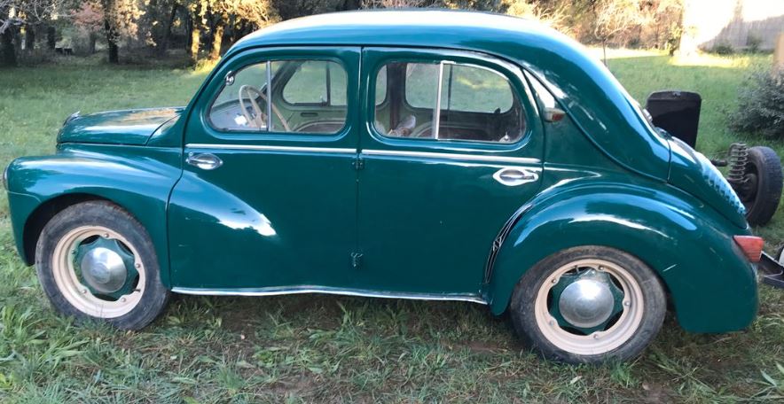 Renault 4CV 1954 verte stationnée dans l’herbe vue de profil