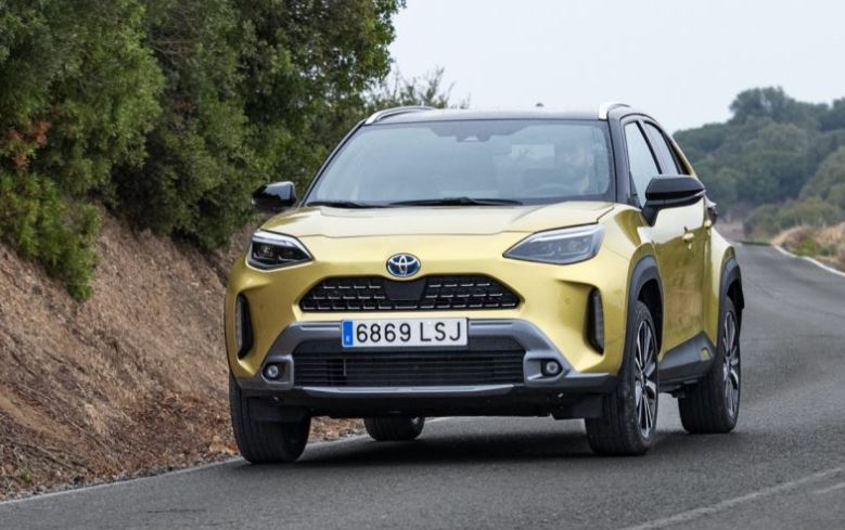 Toyota Yaris Cross hybride jaune en roulage, dérivé SUV de la Yaris