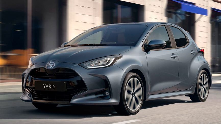 Toyota Yaris grise en mouvement vue trois quarts avant sur route urbaine