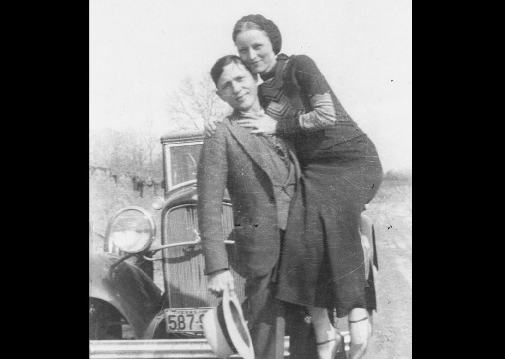 Bonnie Parker et Clyde Barrow photographiés devant une Ford V8 utilisée durant leur cavale