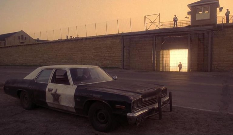 Dodge Monaco des Blues Brothers garée devant la prison au coucher du soleil