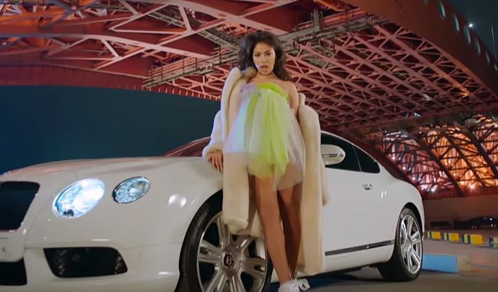Alex Reid du groupe BP Rania posant sur une Bentley dans un clip K-pop