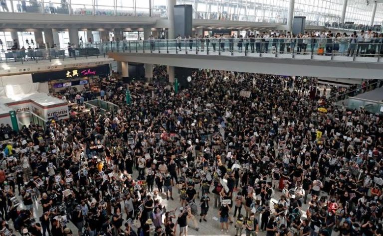 Foule dense dans un aéroport international illustrant l’augmentation du trafic aérien mondial