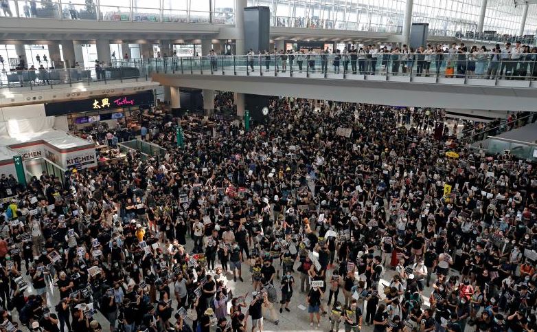 Foule dense dans un aéroport international illustrant l’augmentation du trafic aérien mondial