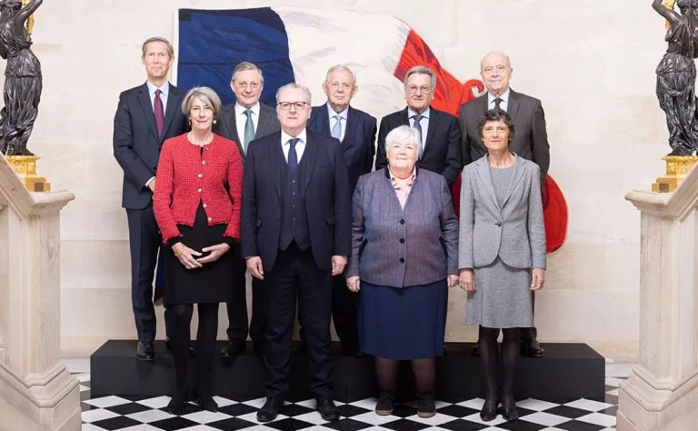 Photo officielle des membres du Conseil constitutionnel devant un drapeau français après le rejet de l’annulation des ZFE.