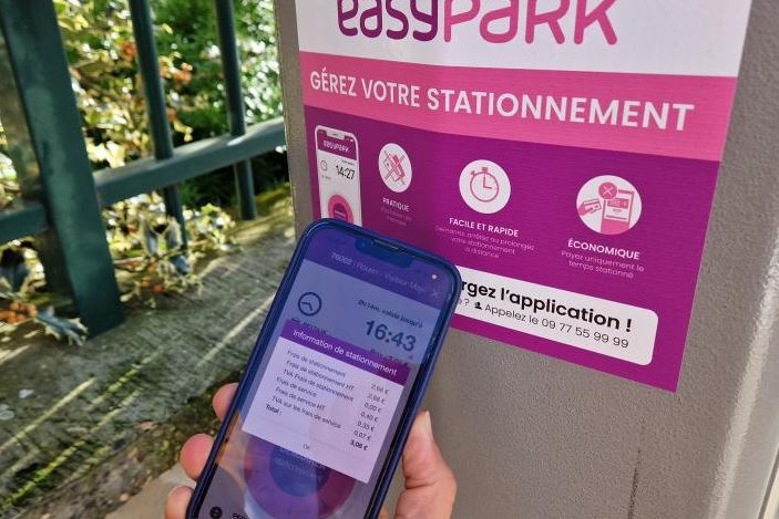 Paiement de stationnement via application mobile devant un panneau EasyPark