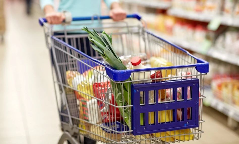 Chariot de supermarché rempli de produits alimentaires dans une grande surface