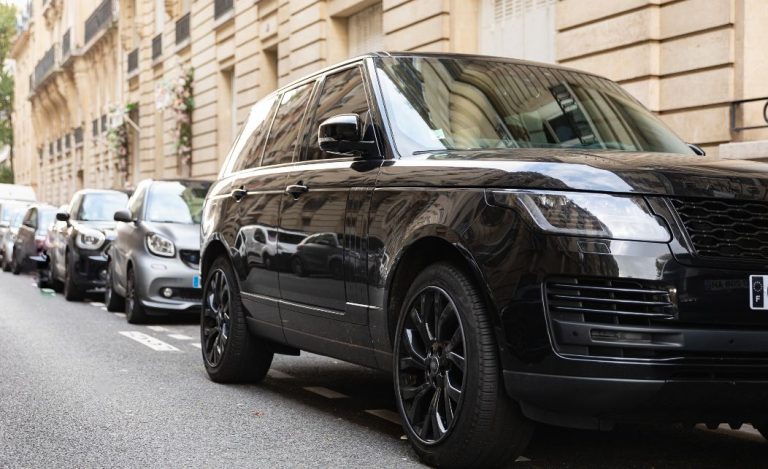 SUV Range Rover noir débordant largement de sa place de stationnement