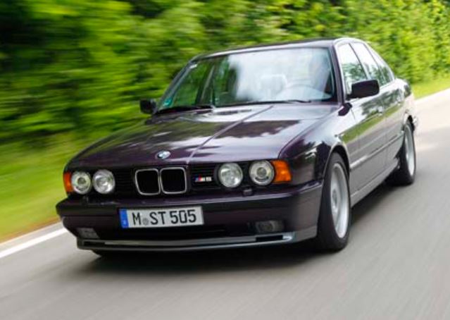BMW M5 E34 noire en mouvement sur route