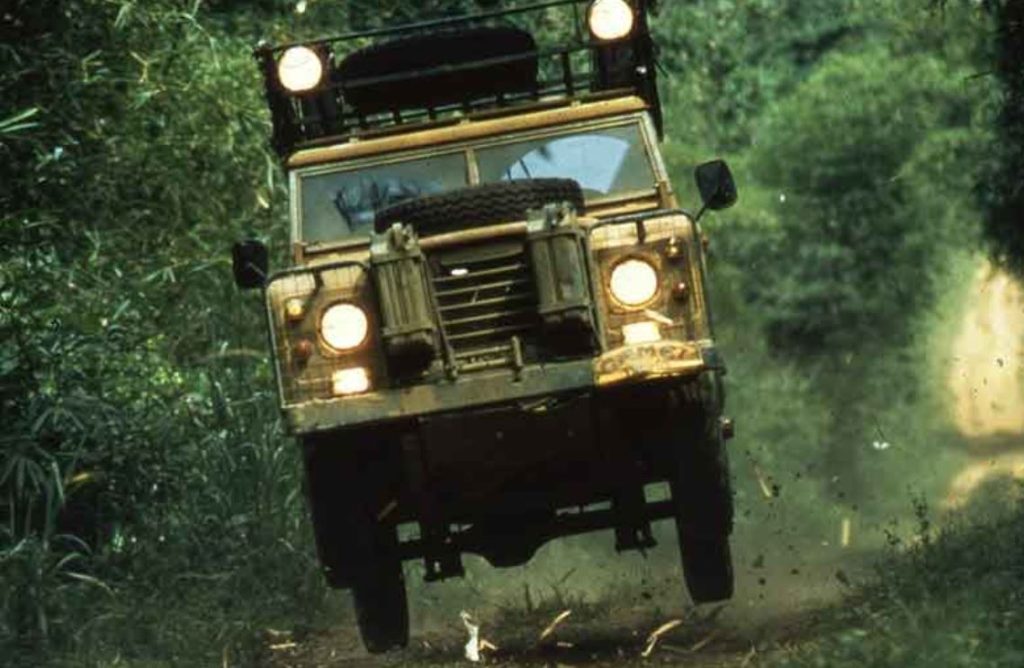 Land Rover Defender Camel Trophy roulant à vive allure sur piste tropicale