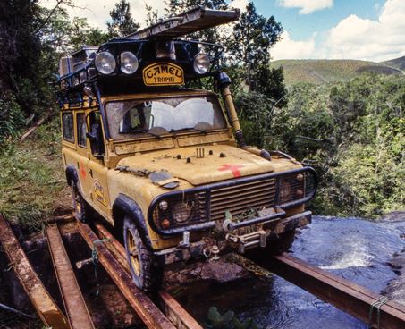 Land Rover Camel Trophy traversant un pont improvisé en pleine expédition