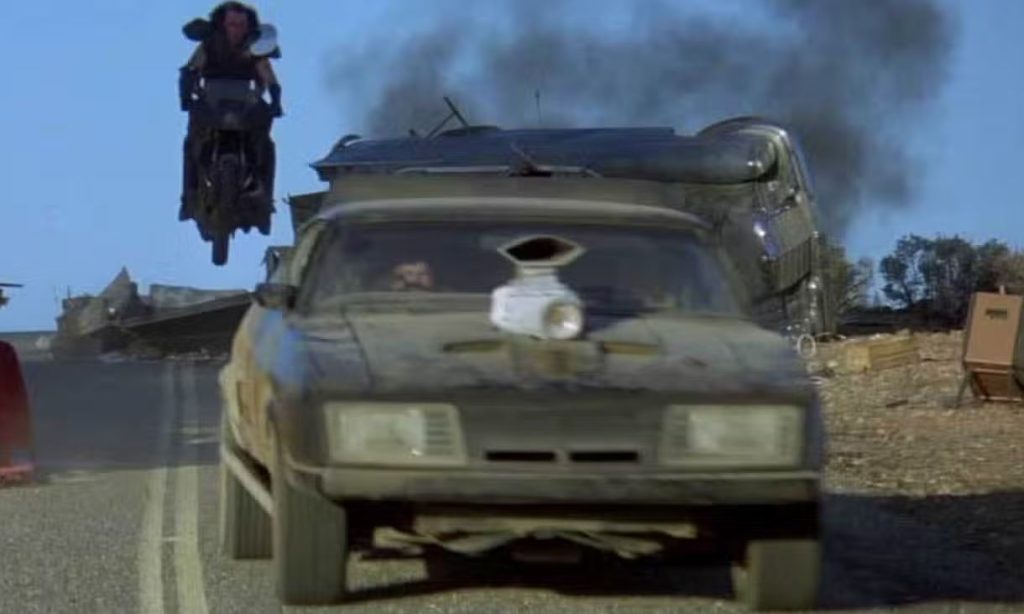 Cascade spectaculaire de Mad Max avec voiture et moto en plein saut