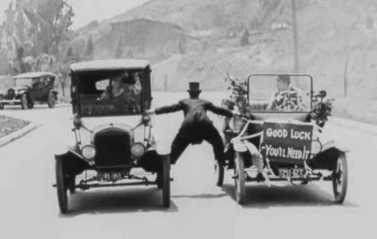 Cascade de voitures du cinéma muet avec deux automobiles anciennes en noir et blanc