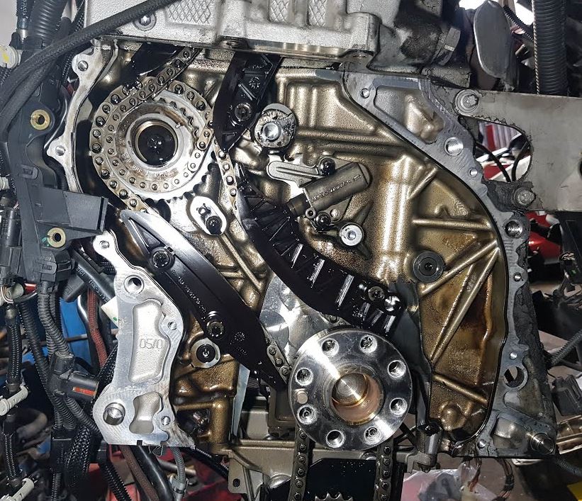 Chaîne de distribution d’un moteur BMW N57 avec guides et tendeur visibles après démontage