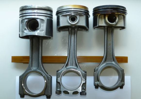 Piston de moteur diesel comparé à deux pistons de moteur essence