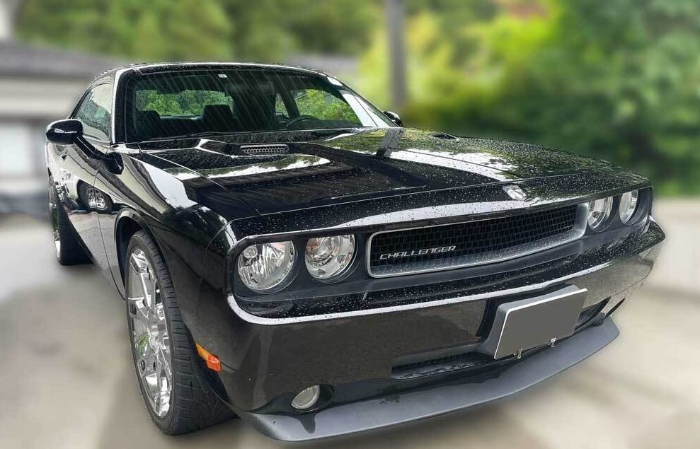 Dodge Challenger noire moderne stationnée après la pluie