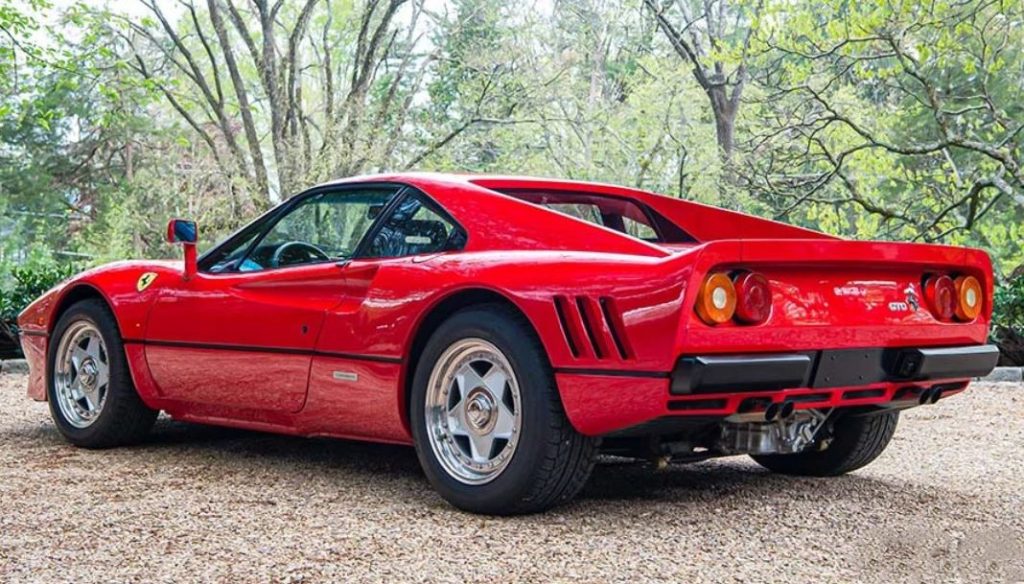 Ferrari 288 GTO rouge vue arrière trois quarts avec ailes larges et jantes d’origine
