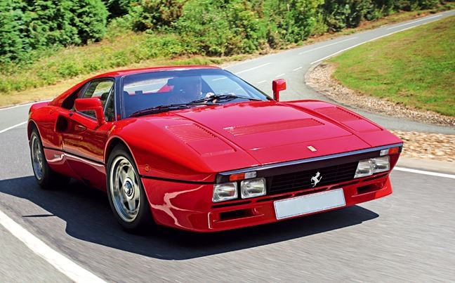 Ferrari 288 GTO rouge vue avant trois quarts sur route en mouvement