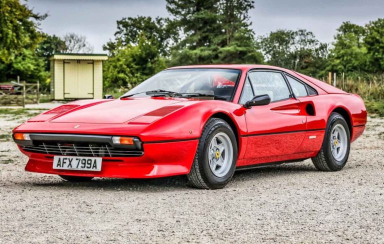 Ferrari 308 GTB rouge vue avant trois quarts sur gravier
