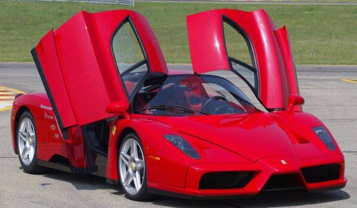 Ferrari Enzo rouge avec portes papillon ouvertes supercar de légende