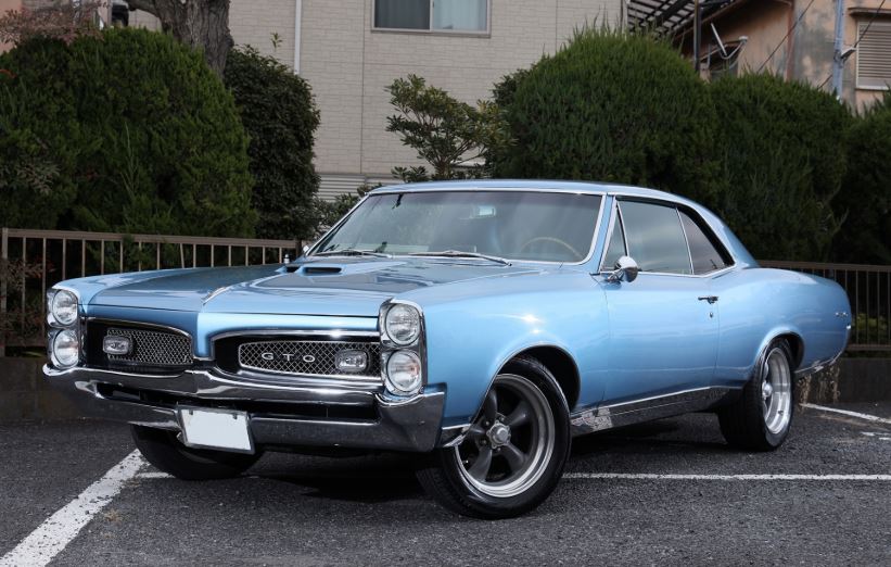 Pontiac GTO bleue des années 1960 stationnée en extérieur