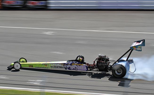 Dragster Top Fuel moderne en accélération avec pneu arrière en fumée