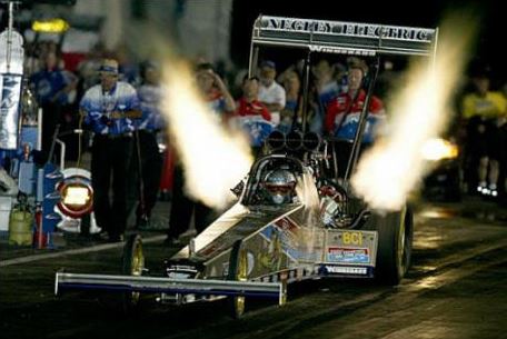 Top Fuel dragster de nuit avec flammes sortant des échappements