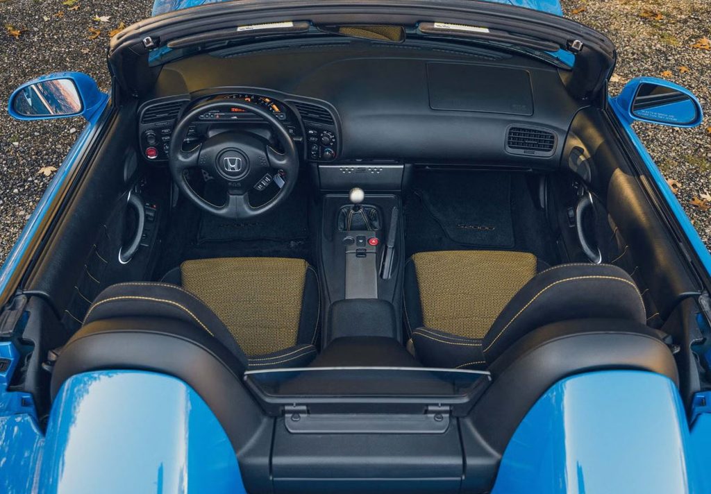Habitacle de la Honda S2000 vu du dessus, avec instrumentation numérique, volant et boîte manuelle à six rapports.