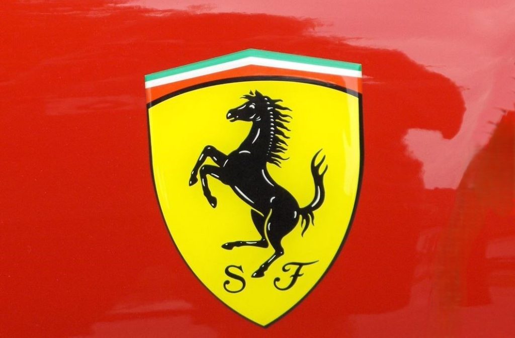 Logo Ferrari avec cheval cabré noir sur carrosserie rouge