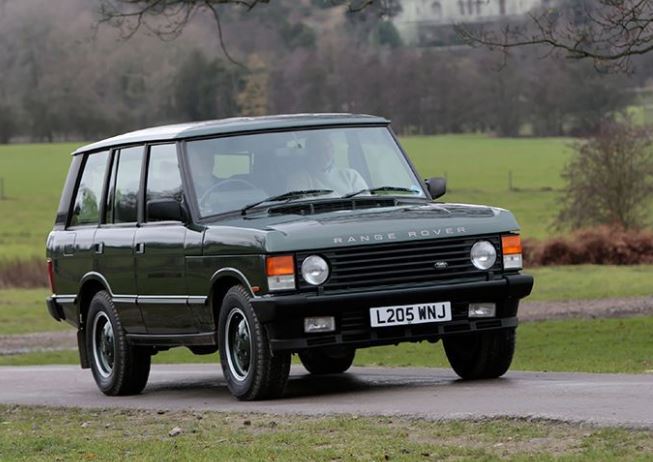 Range Rover Classic vert foncé vue trois quarts avant sur route de campagne