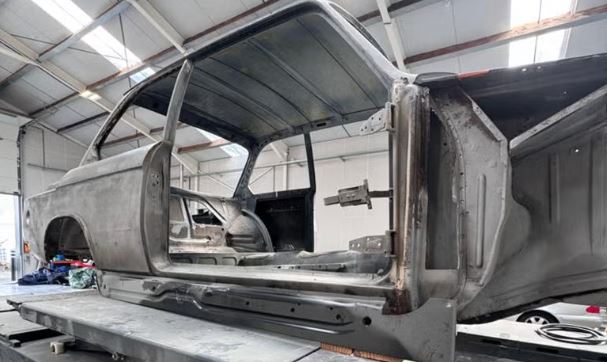 Caisse nue de BMW 2002 1971 en cours de restauration dans un atelier