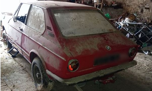 BMW 2002 Touring Tii rouge abandonnée dans une grange poussiéreuse