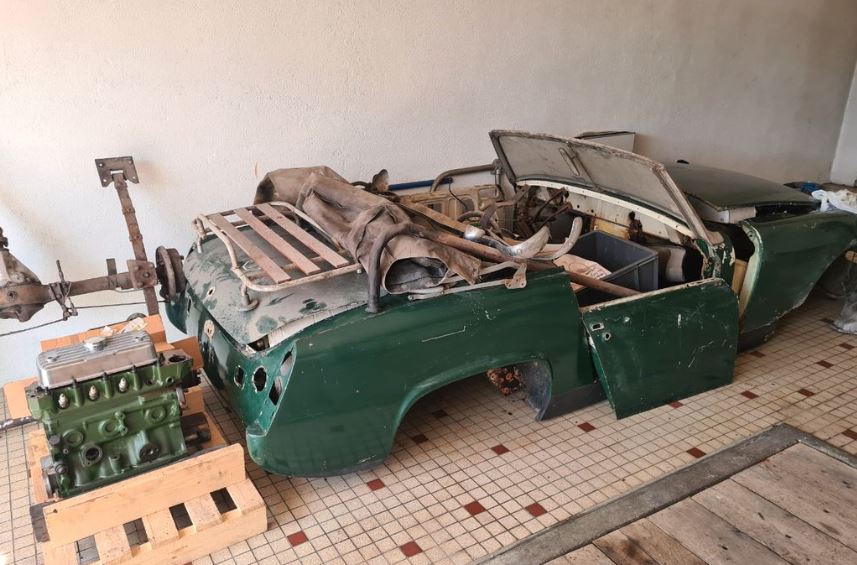 MG Midget MK3 1968 démontée avec moteur posé au sol dans un garage