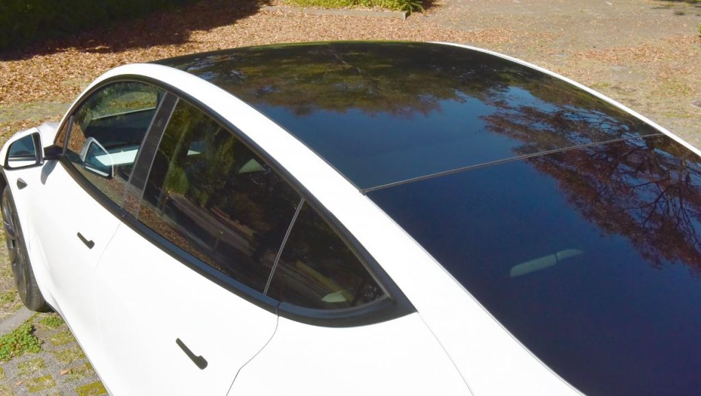 Toit panoramique vitré Tesla Model Y vu de dessus sur carrosserie blanche