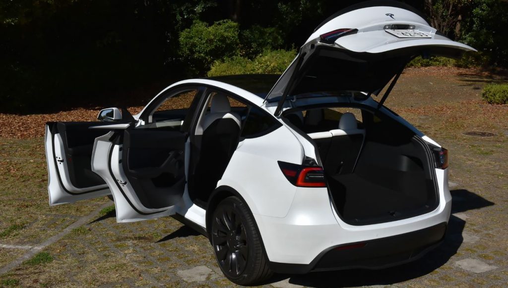 Coffre et portes ouvertes Tesla Model Y montrant la polyvalence du SUV
