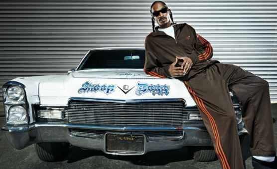 Snoop Dogg posé devant une Cadillac américaine blanche personnalisée