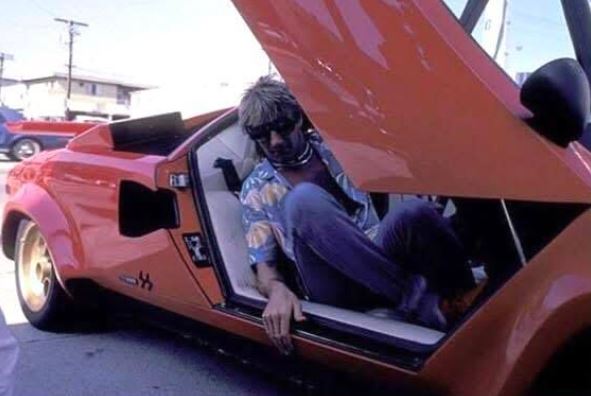 Rod Stewart au volant d’une Lamborghini Countach rouge à portes ouvertes