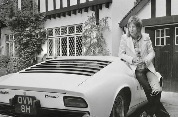 Rod Stewart posant devant sa Lamborghini Miura blanche dans les années 1970