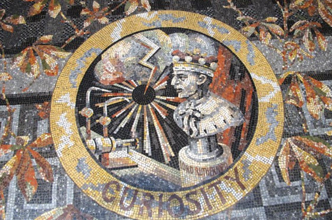 Mosaïque représentant la Curiosité incarnée par le physicien Ernest Rutherford, symbole de la recherche scientifique et du désir de comprendre le monde.
