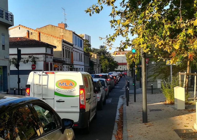 File de véhicules à l'arrêt dans une rue urbaine en heure de pointe, illustrant les embouteillages quotidiens et la saturation du trafic automobile.