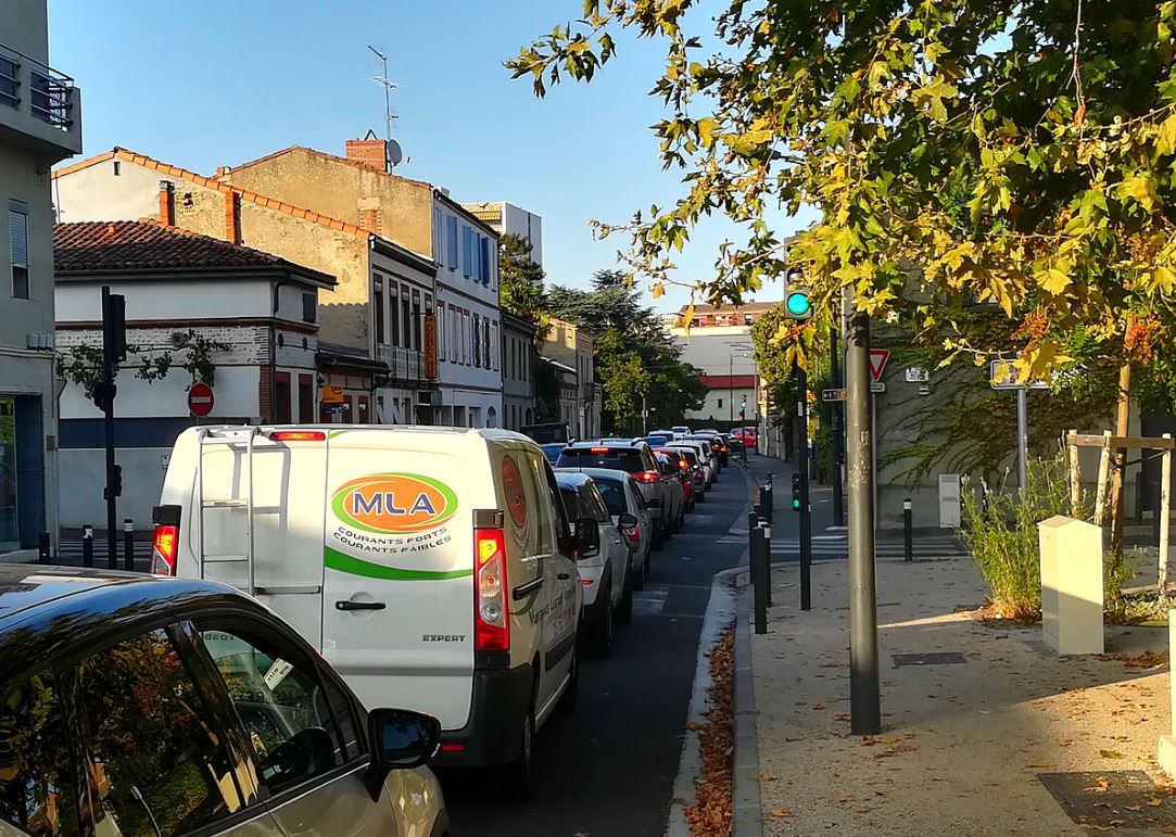 File de véhicules à l'arrêt dans une rue urbaine en heure de pointe, illustrant les embouteillages quotidiens et la saturation du trafic automobile.