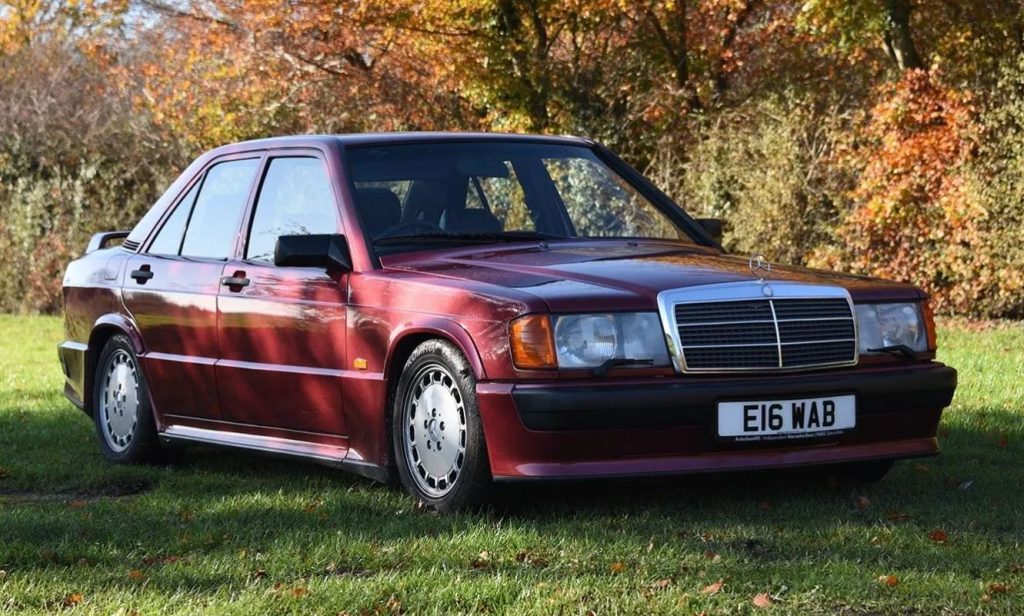 Mercedes 190 E 2.5-16 rouge stationnée dans l’herbe