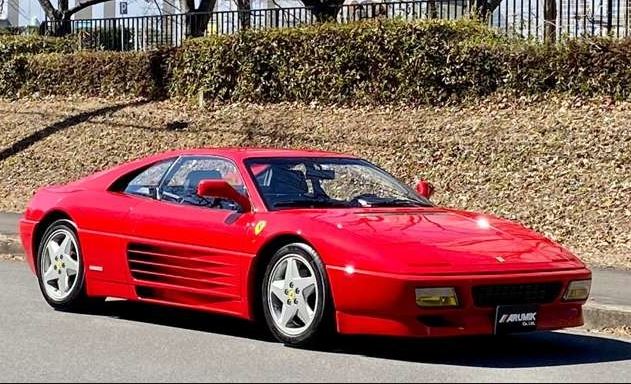 Ferrari 348 rouge de 1990 vue de trois quarts avant avec ses flancs striés caractéristiques
