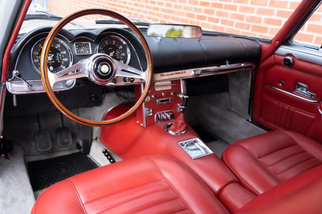 Habitacle de Maserati 5000 GT avec sellerie rouge et volant en bois